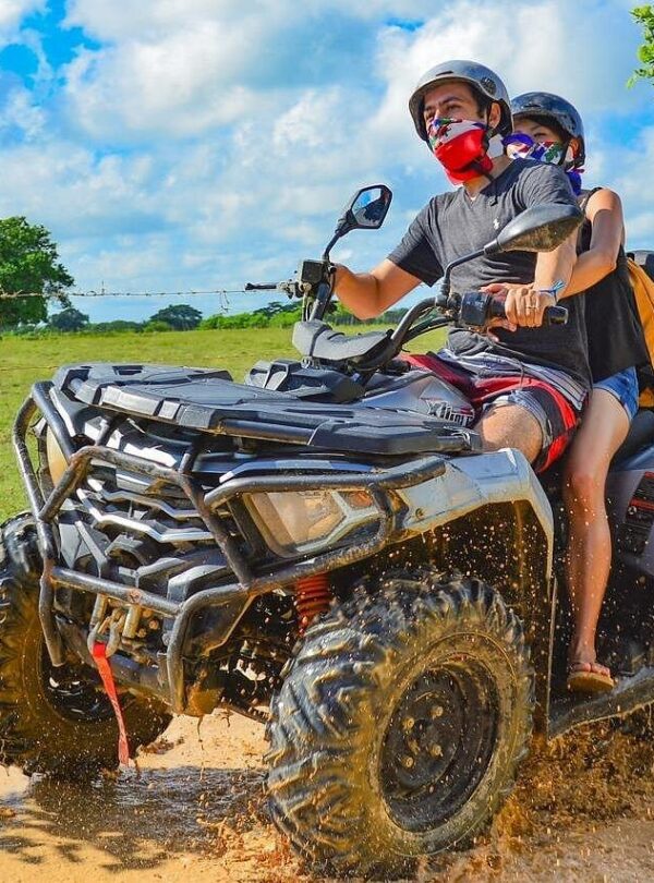ATV splashing through muddy terrain during the tour